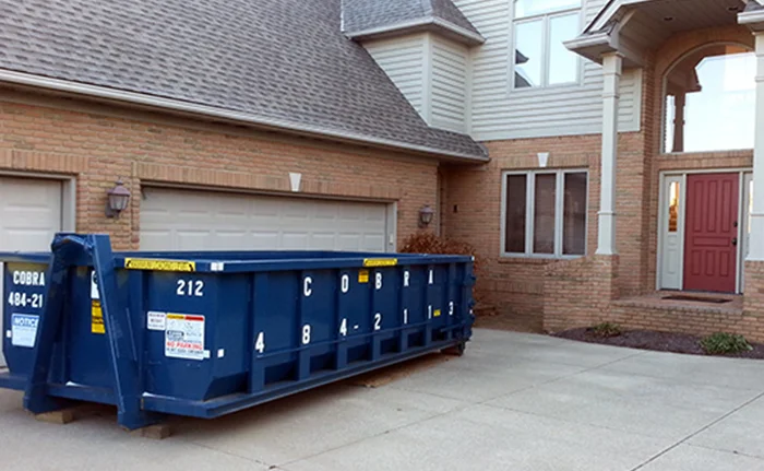 A Cobra Roll Off dumpster delivered in front of a home